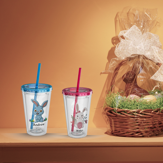 Custom Easter bunny tumbler with personalized name. Adorable blue and pink bunny designs on a clear, reusable acrylic cup with matching lid and straw. Perfect for kids' Easter baskets, spring gifts, and festive holiday drinks."